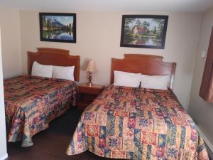 a hotel room with two beds and two lamps at Relax Inn-Collingwood in Collingwood