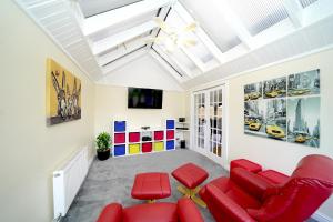 sala de estar con sillas rojas y techo en Lower Lodge, en Cardeston