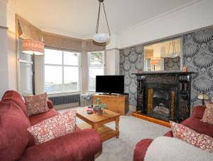 Una sala de estar con dos sofás y una chimenea. en Llwyn Onn, en Criccieth