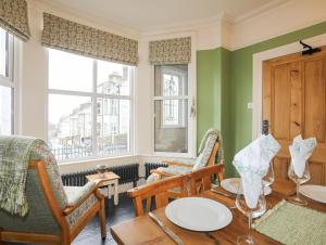 Un comedor con mesa y sillas y una ventana. en Llwyn Onn, en Criccieth