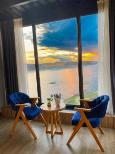 イスタンブールにあるMarina Fener Hotel & Suiteの椅子2脚とテーブル、大きな窓が備わる客室です。