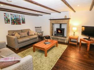a living room with a couch and a fireplace at Harrow Cottage in Bakewell