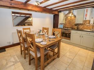 a kitchen with a wooden dining table and chairs at Harrow Cottage in Bakewell