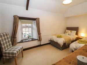 a bedroom with two beds and a window at Harrow Cottage in Bakewell