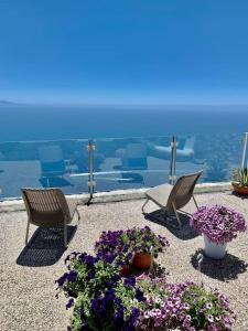 Duas cadeiras e flores num pátio com vista em La casa del '600 Holiday House Amalfi Coast em Amalfi