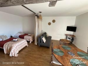 a bedroom with two beds and a table and a couch at Domaine de la Terrasse in Carbonne