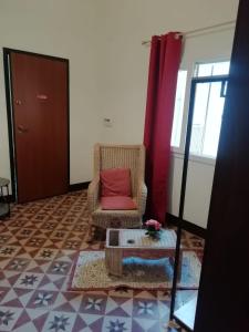 a living room with a chair with a red pillow at SAT Appartamenti Locazioni turistiche brevi-G&P HOLIDAY HOME in Trapani