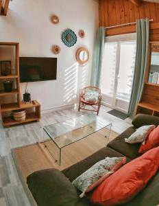 uma sala de estar com um sofá e uma mesa de vidro em La Caravelle - Chalet t2 climatisé lit queen size ou twin em Tarbes