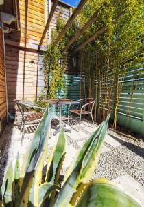 een patio met een tafel, een stoel en een plant bij La Caravelle - Chalet t2 climatisé lit queen size ou twin in Tarbes