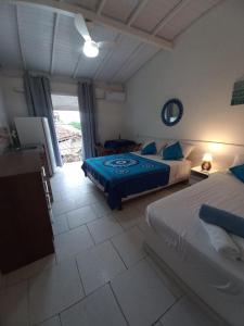 1 dormitorio con 2 camas y 1 habitación con ventana en OLHO GREGO Hospedagem em ARRAIAL d'AJUDA, en Arraial d'Ajuda