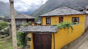 a yellow house with a gate and a mountain at Casa Bartolin in Gédrez +10 photos
