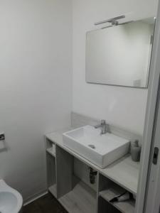 a white bathroom with a sink and a mirror at SAT Appartamenti Locazioni turistiche brevi-G&P HOLIDAY HOME in Trapani