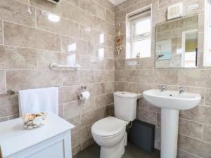 a bathroom with a toilet and a sink at 21 Siesta Mar in Mundesley +24 photos