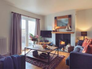 uma sala de estar com uma mesa e uma lareira em Craster Reach em Alnwick