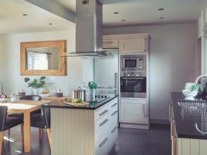 a kitchen with white cabinets and a stove top oven at Craster Reach in Alnwick