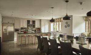 a kitchen with a table and some chairs and a kitchen with at Oughtershaw Hall in Skipton