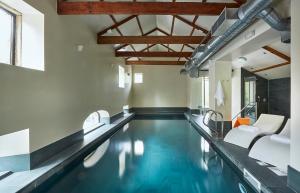 a swimming pool with blue water in a building at Oughtershaw Hall in Skipton