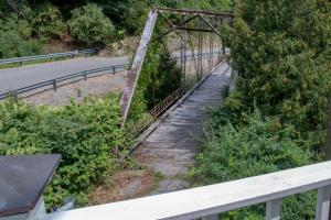 un viejo puente oxidado sobre una carretera en Elk River Hotel & Cafe en Sutton