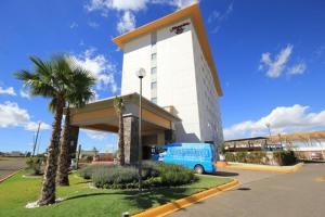 een blauw busje geparkeerd voor een gebouw bij Hampton Inn by Hilton Silao-Aeropuerto, Mexico in Silao