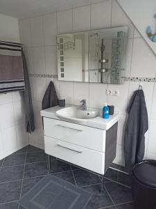 a bathroom with a sink and a mirror at Schöne Ferienwohnung mit Balkon auch für Handwerker und Monteure in Borsfleth