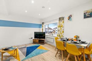 a dining room with a table and a tv at April Disc - Long Stay - Contractors in Swindon