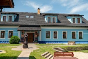 uma casa azul com uma estátua em frente em Hospůdka na Haldě em Boršice