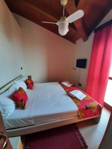 a bedroom with a bed with a ceiling fan at Casa Amizade B&B in Pedra Badejo