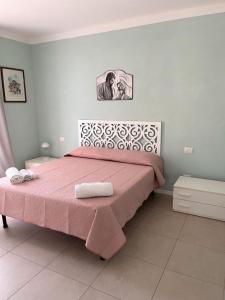 um quarto com uma cama rosa e uma colcha rosa em TRILO COPPO CON SPIAGGIA E POSTO AUTO em Numana