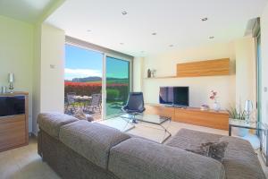 a living room with a couch and a flat screen tv at El Chalet de Lola in Santillana del Mar