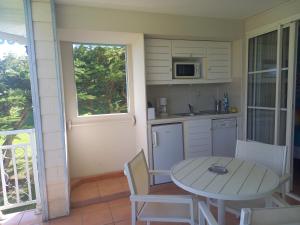 a small kitchen with a table and a table and chairs at Appartements VUE MER et PARC in Sainte-Luce