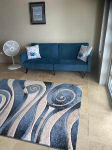 a blue couch in a living room with a carpet at Top of the Hill Blue Sunshine in Long Swamp