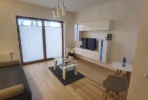 a living room with a coffee table and a kitchen at Novum apartment in the city center in Kraków +2 photos