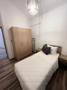 1 dormitorio con 1 cama blanca grande y armario en ALTAVILLAS Apartment 7 Deluxe GENNARO, en Kakí Vígla