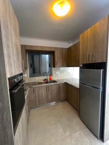 cocina con armarios de madera y nevera de acero inoxidable en ALTAVILLAS Apartment 7 Deluxe GENNARO, en Kakí Vígla