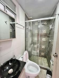 a bathroom with a toilet and a glass shower at Las Aguas Social Experience in Bogotá