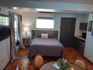 1 dormitorio con 1 cama y 1 mesa con sillas en Elk River Hotel & Cafe en Sutton