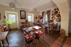 une salle à manger avec des tables et des chaises en bois dans l'établissement Domaine de la Terrasse, à Carbonne