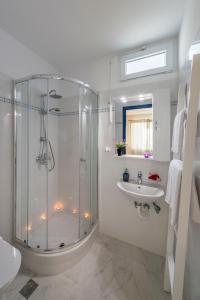 een witte badkamer met een douche en een wastafel bij Sea View Studios in Finikas