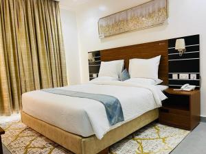 una camera da letto con un letto grande con testiera in legno di Randa Boutique Hotel a Kigali Altre 3 foto