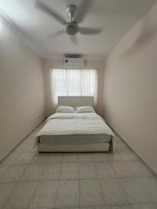 um quarto com uma cama e uma ventoinha de tecto em Dagang Homestay em Ampang