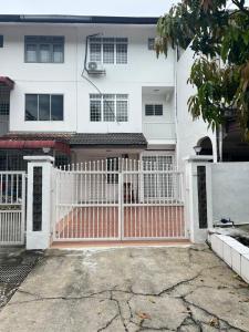 Uma casa branca com um portão rosa à frente. em Dagang Homestay em Ampang