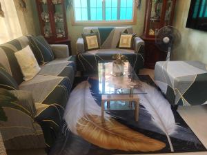 uma sala de estar com um sofá e uma mesa em Affordable Spacious Bedroom & Bathroom near DVO Airport em Davao
