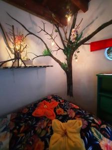 1 dormitorio con 1 cama con un árbol pintado en la pared en Eco Hostal Tierra de Agua y Fuego, en San Rafael