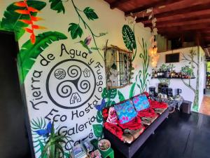 a room with a couch against a wall with a mural at Eco Hostal Tierra de Agua y Fuego in San Rafael
