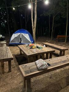 una mesa de picnic con una tienda en ella por la noche en Espaço camping -Barraca 3, en Itapira