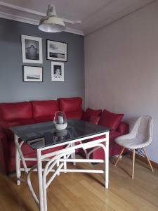 uma sala de estar com um sofá vermelho e uma mesa em Apartamento Barrionuevo em Córdoba