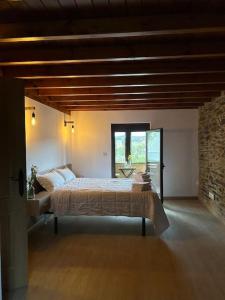 a bedroom with a large bed and a window at A Barreira in Ferrol