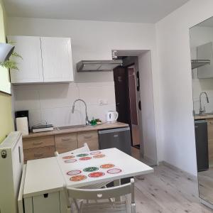 uma cozinha com uma mesa branca e uma bancada em Apartament Zielony Gaj Ustroń Wczasowa 90 em Ustroń