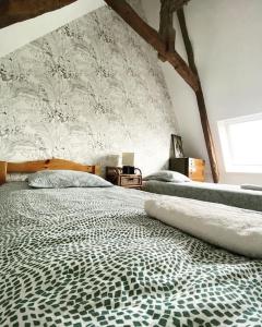 a bedroom with a large bed with a wall at Domaine Des Hêtres in Longraye