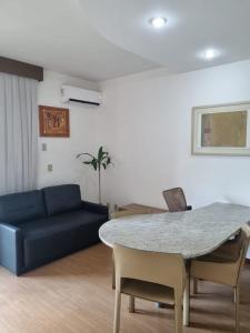 a living room with a blue couch and a table at Flat Pancetti in Belo Horizonte